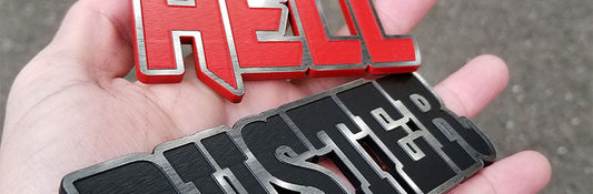Hell Duster custom emblem with red and black satin engraved lettering made from UV rated acrylic held outdoors.
