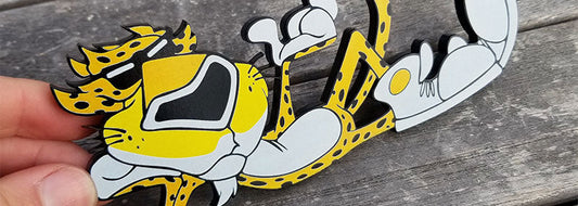 Cool Cheetah layered cartoon emblem with yellow and grey detailing made from UV rated acrylic held on wooden surface.