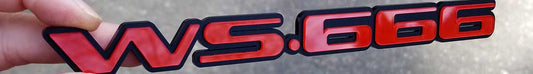 WS666 automotive badge in gloss red lettering mounted on matte black base made from UV rated acrylic held outdoors.