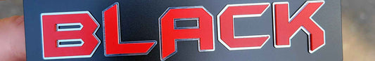 Rectangular black emblem with satin red raised lettering and brushed stainless outline accents.