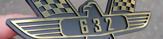 Satin black and brushed gold 3D Galaxie crossed flags emblem with raised 632 numerals.
